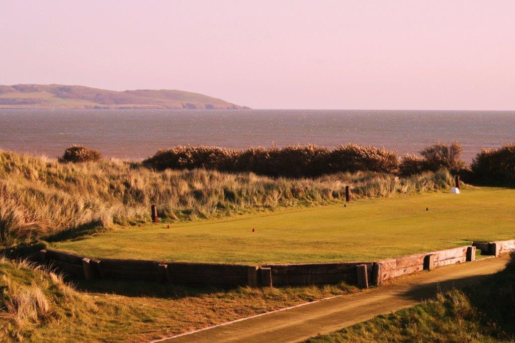 Golfgrün mit Meeresblick im Sonnenuntergang auf dem Island Golfplatz in Dublin, Irland