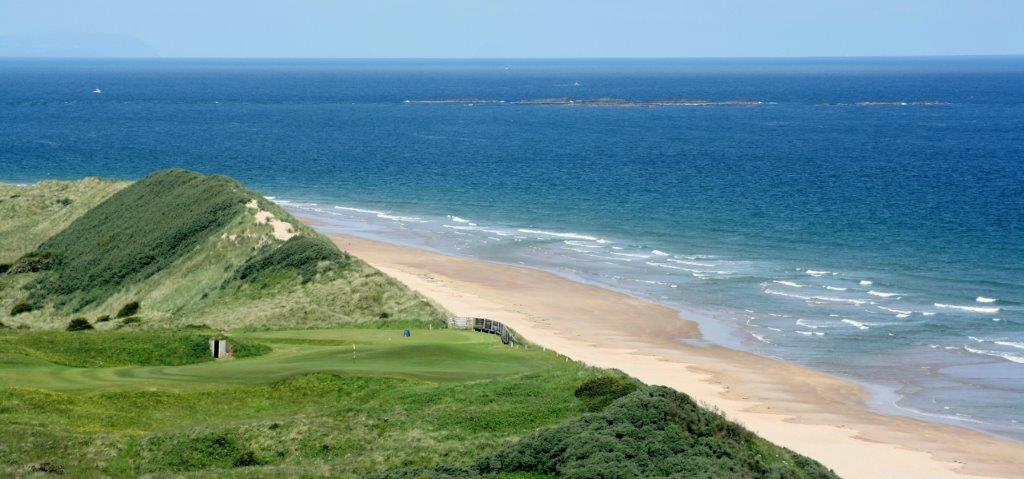 Golfgrün mit Strand und Meeresblick auf dem Royal Portrush Dunluce Golfplatz in Nordirland