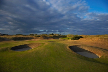 Golfgrün mit Bunker im Sonnenuntergang auf dem Portmanock Links Golfplatz in der Nähe von Dublin, Irland