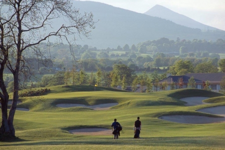 Golfgrün mit Bunker und Golfspieler auf dem Druids Health Golfplatz in der Nähe von Dublin, Irland