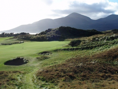 Golfgrün mit Blick auf die Berge auf dem Royal County Down Championship Golfplatz in Nordirland